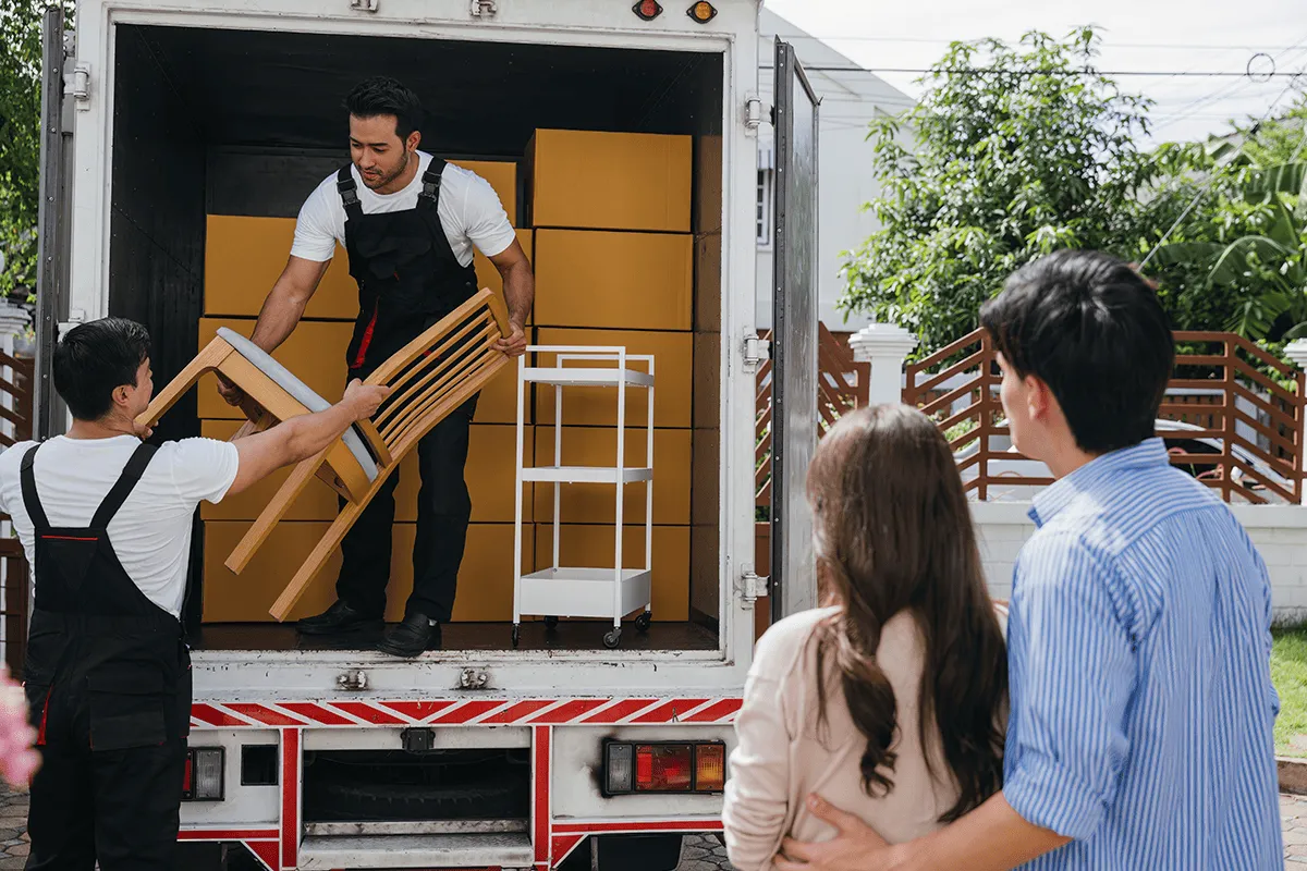 Personal de mudanzas trasladando cajas y muebles durante una mudanza residencial
